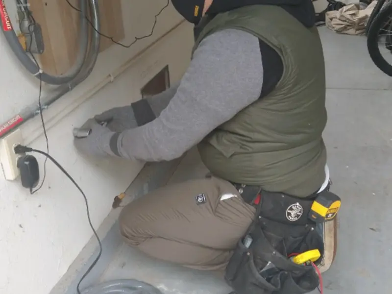 Electrician performing outlet wiring in a Newtown garage